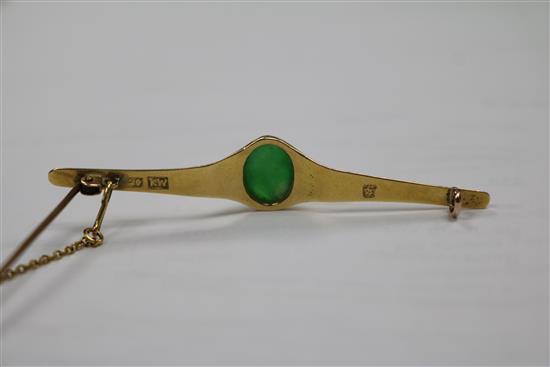 A Chinese yellow metal and jadeite cabochon bar brooch, 62mm.